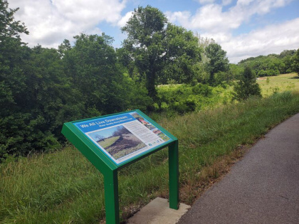 sign on a pathway next to trees